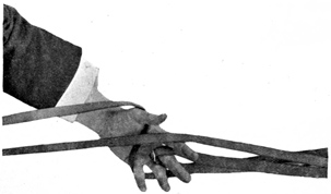Fig. 76.&mdash;Double reins in left hand: one crossed, the
other hooked up on middle finger.